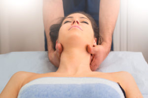 Therapist massaging the neck of woman In the by a professional Therapist massaging the neck of woman In the by a professional in studio